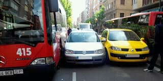Un autobús y dos coches en dos carriles de la Avenida de Madrid en Zaragoza.