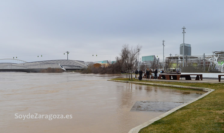 Numerosos curiosos se han acercado a ver la crecida del Ebro junto a la Zona Expo.