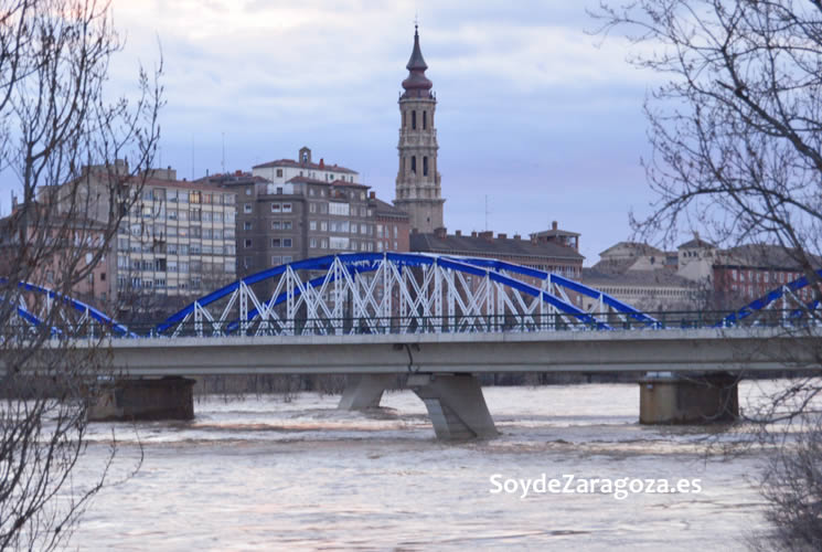 El nivel del agua a su paso por el Puente de Hierro es muy alto. Aquí se ve la torre de La SEO de fondo.