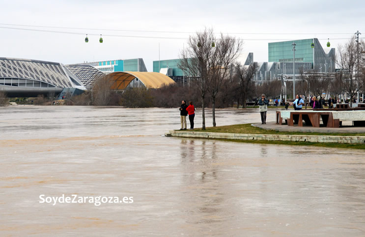 Muchas personas se acercan a hacer fotos a la crecida del río.