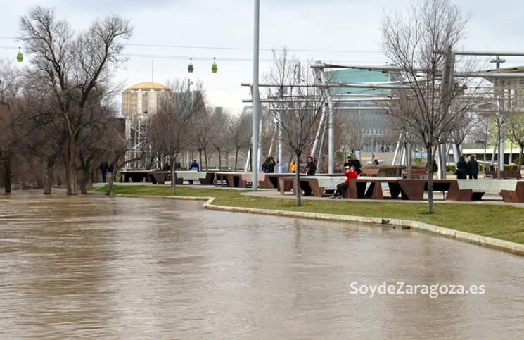 Los zaragozanos pasean por la zona observando la fuerza y altura del agua