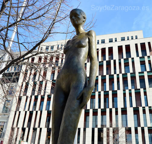La escultura 'Mujer con azul' de la Plaza de España con Puerta Cinegia de fondo.